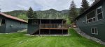 Great covered deck overlooking a large greenspace and the river along with mountain views.